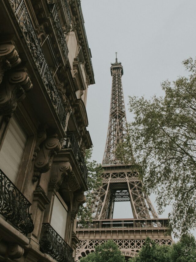 Photo showing the Eiffel Tower from a quiet street in Paris. Photo by Daniel Roe on Unsplash